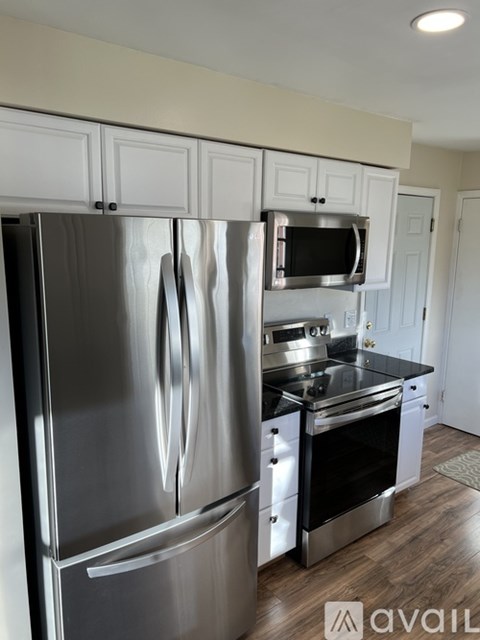 A modern kitchen with a stainless steel refrigerator and microwave.