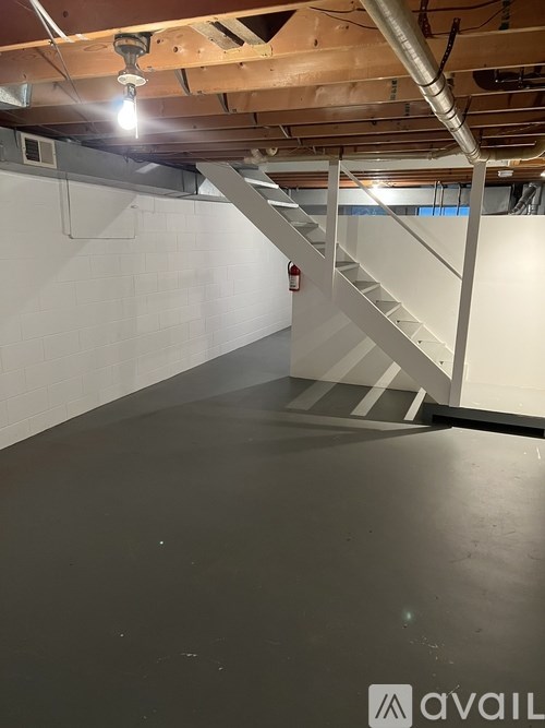 A room with a staircase and a fire extinguisher.