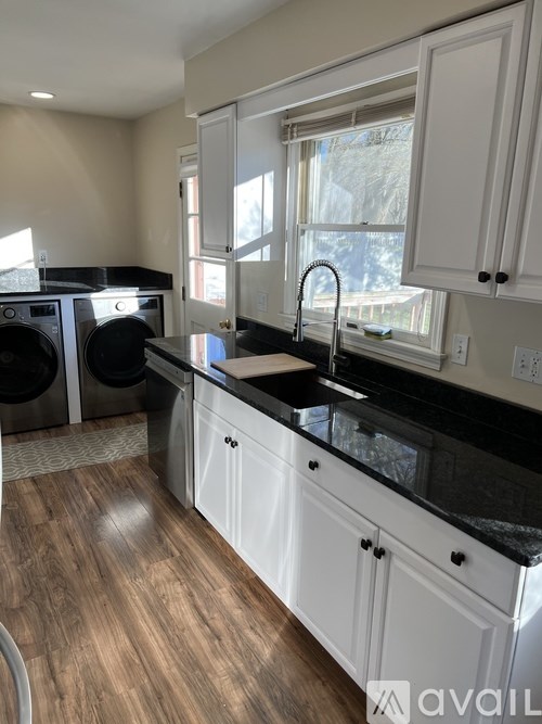 A kitchen with black countertops and white cabinets.