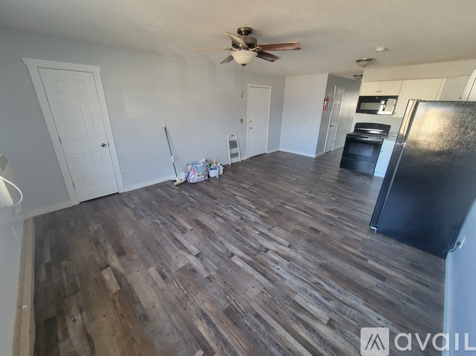 A room with wooden flooring and a ceiling fan.