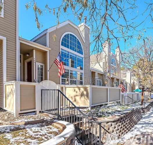 A row of houses with a flag hanging from the front of the first house.