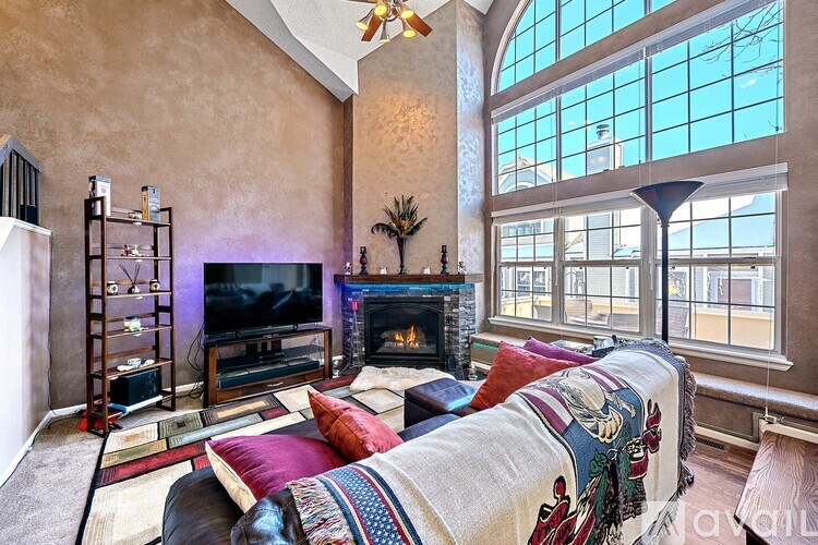 A living room with a fireplace and a large window.