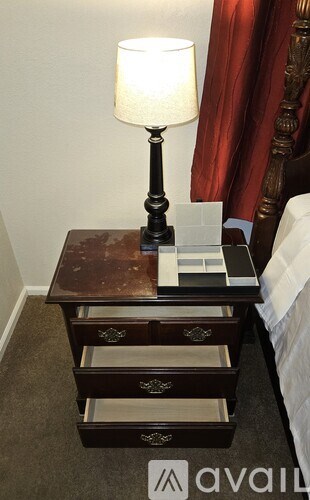 A lamp on a table with drawers underneath it.