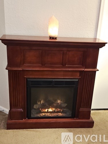 A lit fireplace with a flame on top.