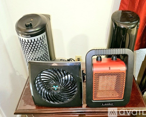 A black fan and a red Laskor fan on a wooden table.