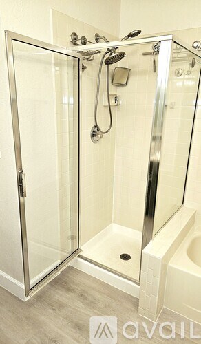 A shower stall with a glass door and a drain in the bottom.
