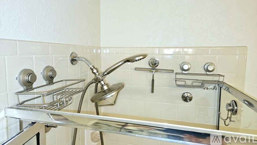 A chrome shower head and faucet in a bathroom.