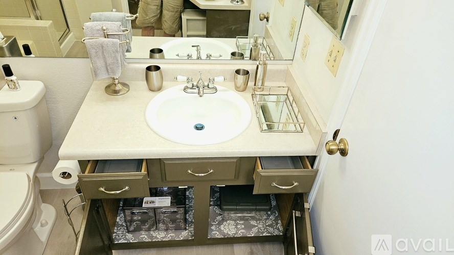 A bathroom sink with a mirror above it and a toilet to the left.