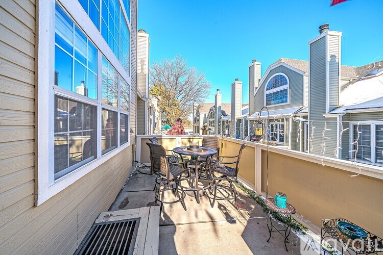 A sunny balcony with a table and chairs.