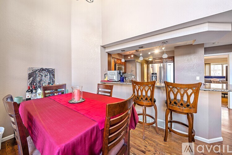 A dining room with a table set for two and chairs around it.