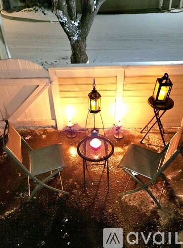 A cozy outdoor seating area with lanterns and candles.
