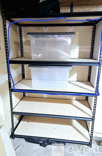 A shelving unit with three shelves, the top shelf has a plastic bag on it, the middle shelf has a white container, and the bottom shelf is empty.