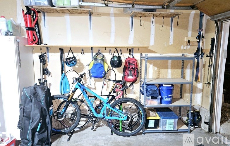 A bike is hanging on a wall in a garage.