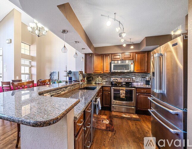 A modern kitchen with wooden cabinets and stainless steel appliances.