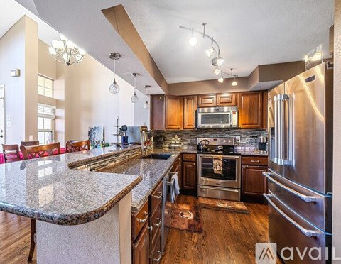 A modern kitchen with wooden cabinets and stainless steel appliances.
