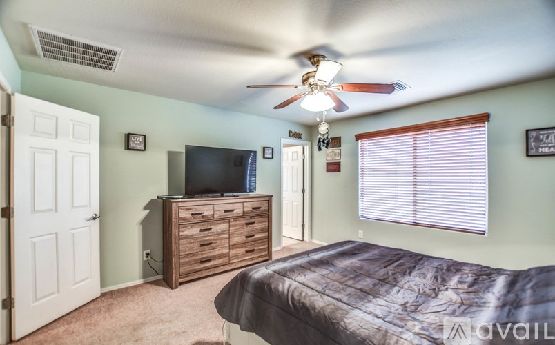 A bedroom with a bed, dresser, and television.