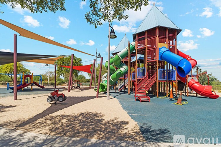 A playground with a red toy car and a green slide.