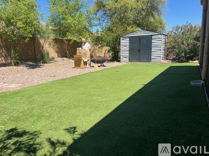 A backyard with a shed and a green lawn.