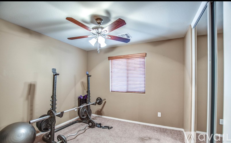 A room with a ceiling fan and exercise equipment.