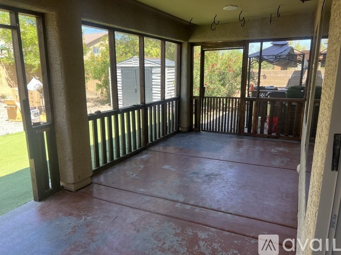 A room with a balcony and a view of a backyard.