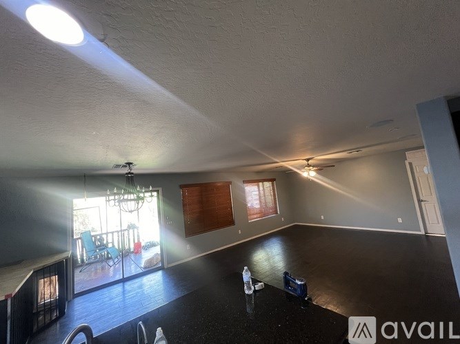A room with a ceiling fan and a large window.
