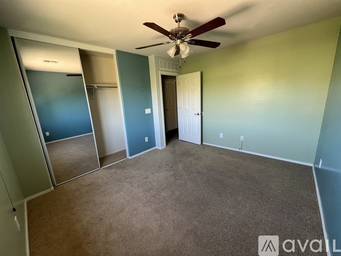 A room with a ceiling fan and a carpeted floor.