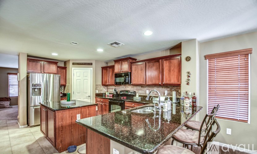 A kitchen with wooden cabinets and granite countertops.
