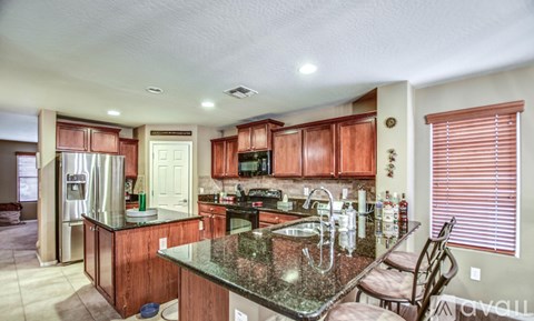 A kitchen with wooden cabinets and granite countertops.