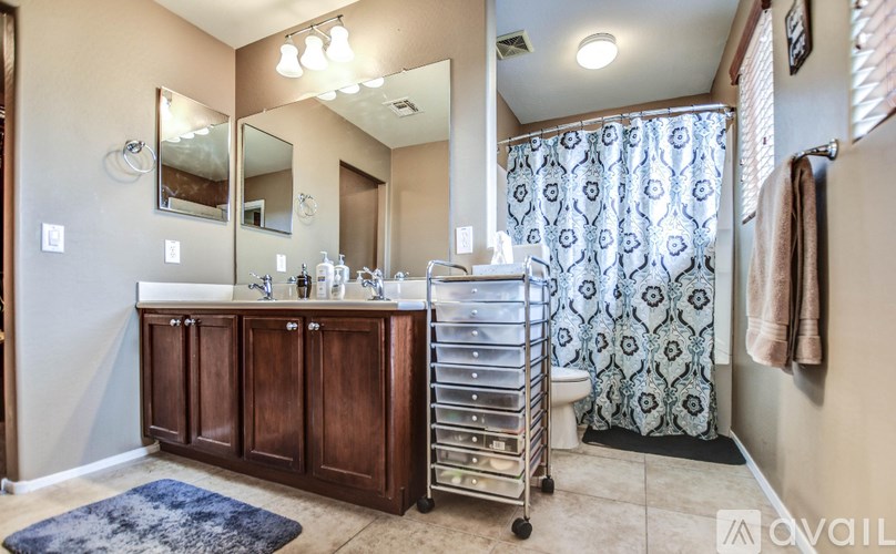 A bathroom with a double sink vanity and a shower with a black and white curtain.