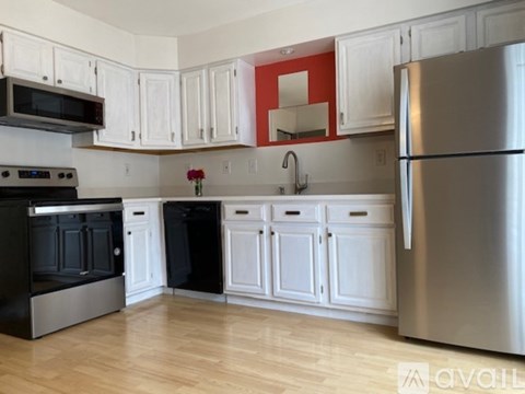 A kitchen with white cabinets and a black stove top oven.