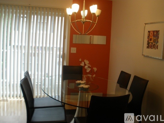 A glass table with chairs and a chandelier in a room.