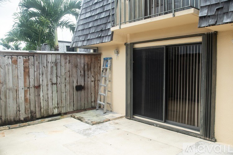 A wooden fence with a ladder and a window with a black blind.
