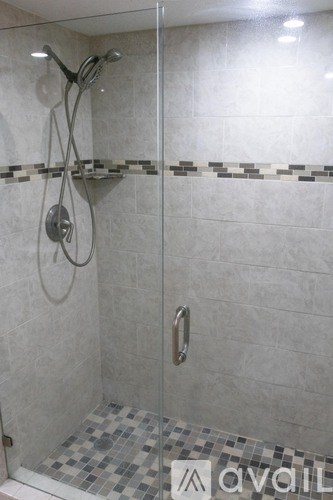 A shower area with a glass door and a tiled floor.