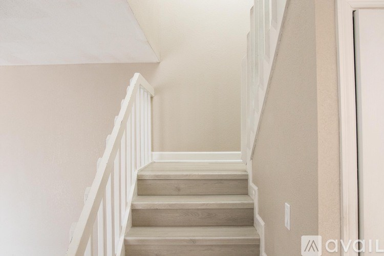 A staircase with a white railing and wooden steps.