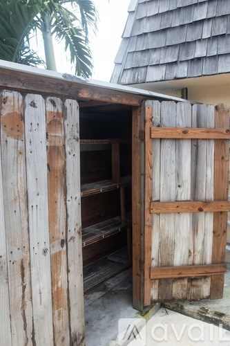 A wooden door is open to a storage area.