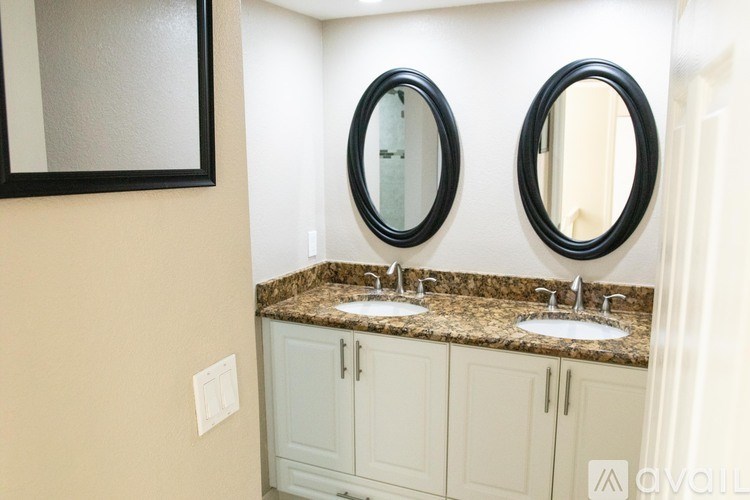 A bathroom with two sinks and two mirrors.
