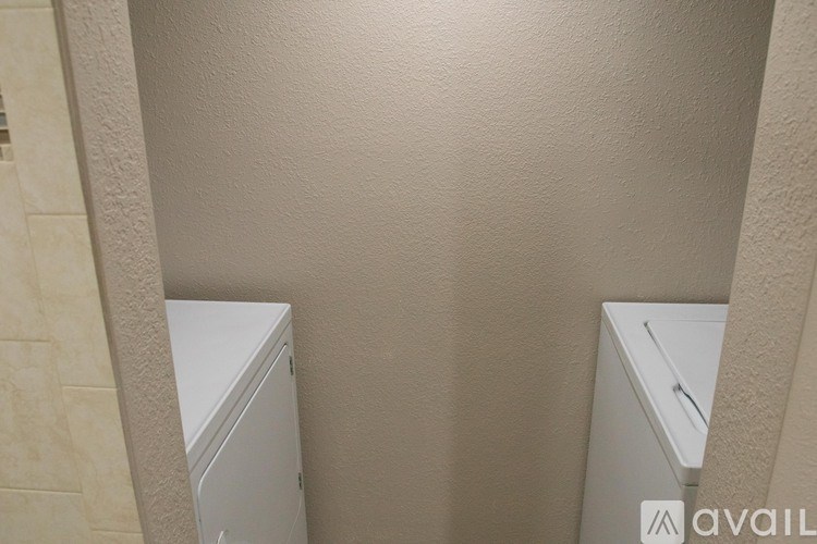 A white cabinet is in the corner of a room.