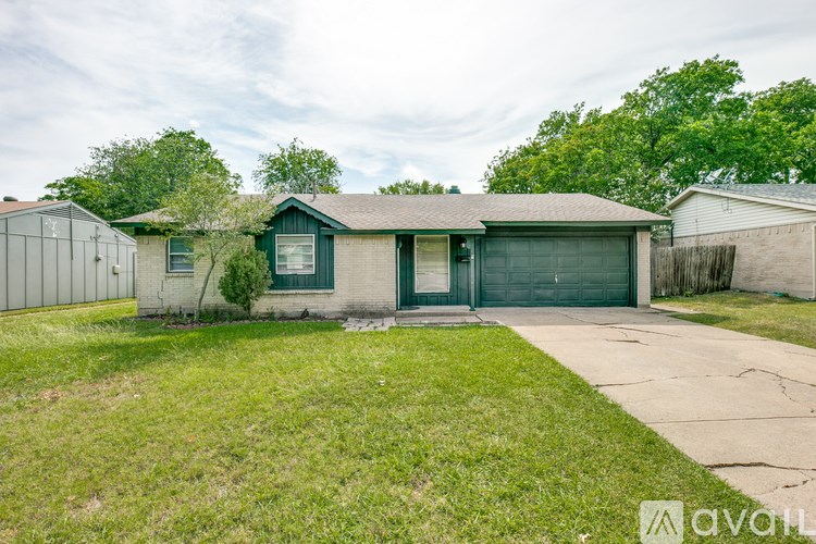 A house with a green lawn and a grey garage door.
