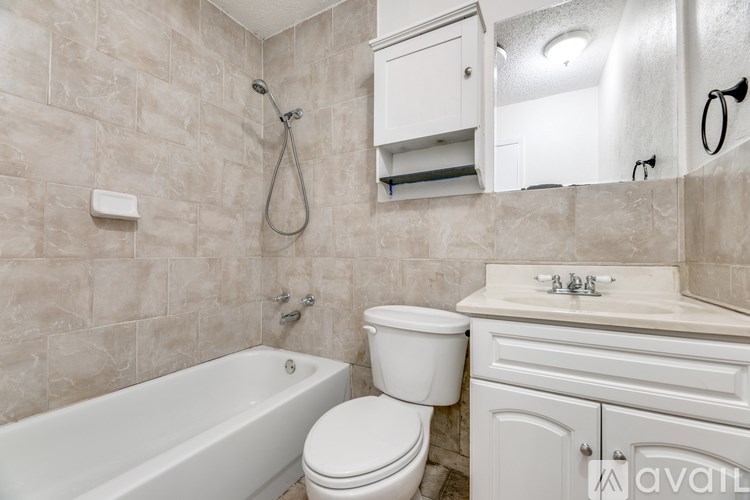 A bathroom with a white tub, toilet, and sink.