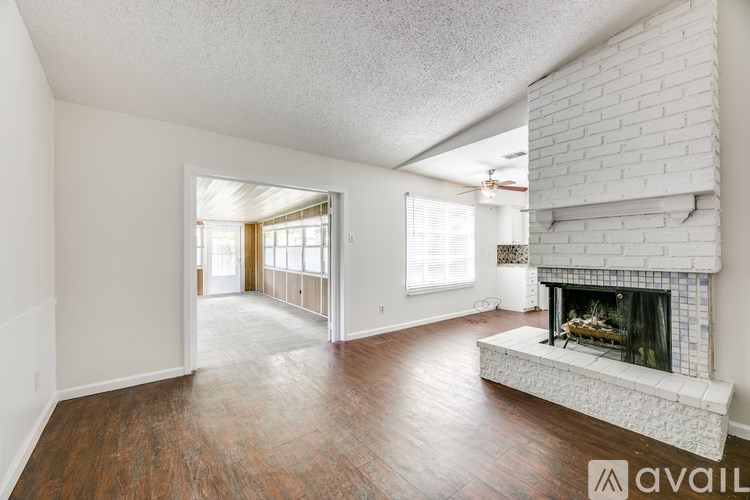 A spacious living room with a fireplace and wood flooring.
