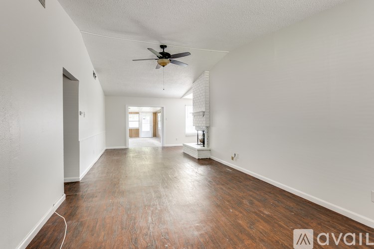 A room with wooden floors and a ceiling fan.