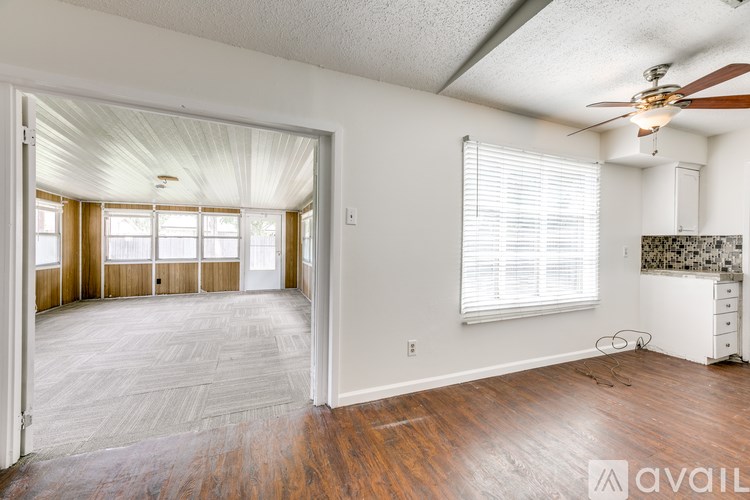 A room with a ceiling fan and a wall-mounted shelf.