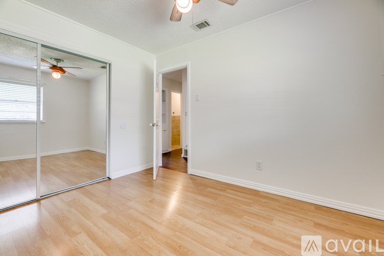 A room with a wooden floor and a ceiling fan.