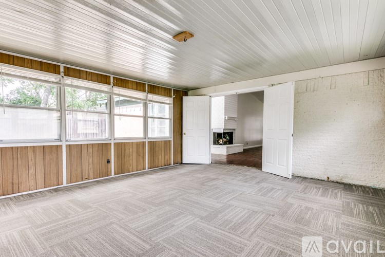 A room with a carpeted floor and a fireplace.