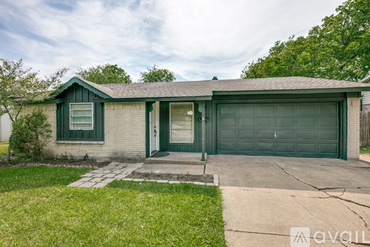 A house with a green garage door and a grey roof.