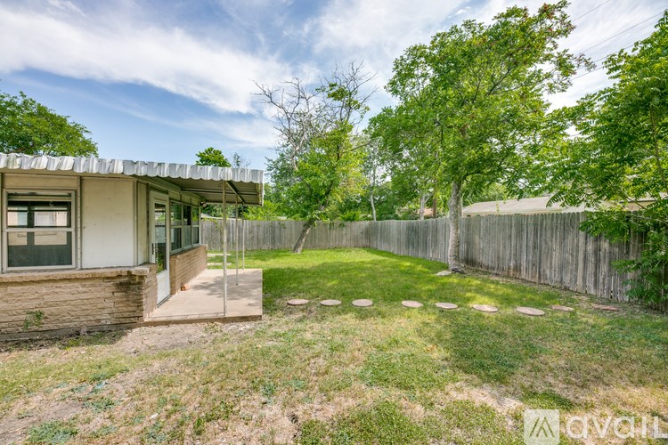 A backyard with a fence and a house.