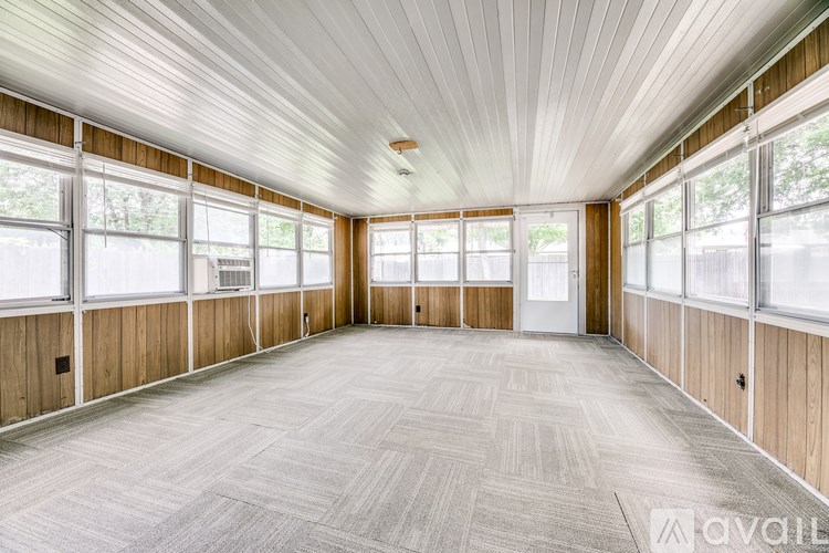 A spacious room with wooden walls and a carpeted floor.