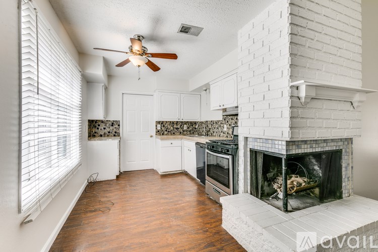 A living room with a fireplace and a fan.