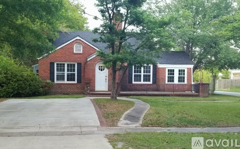 A red brick house with a white door and windows.