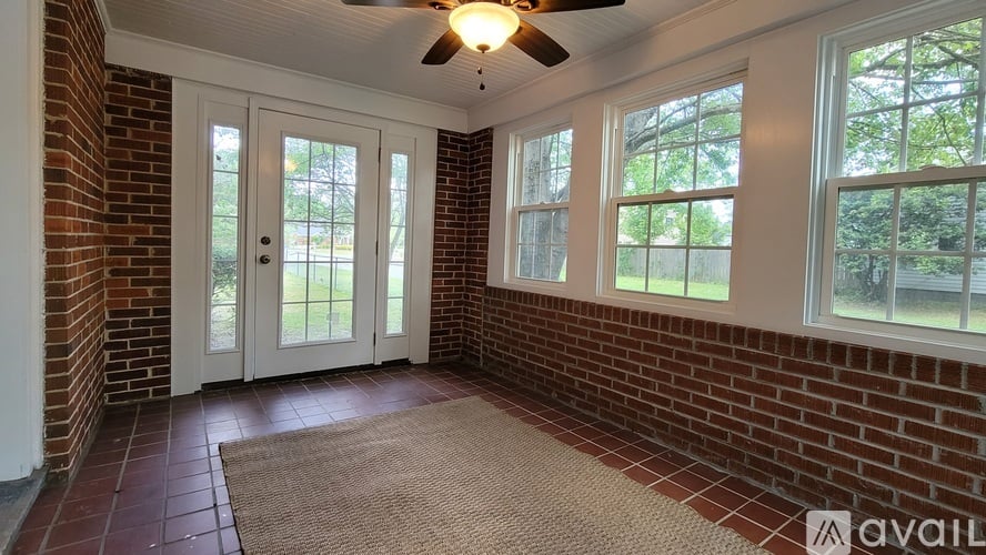 A room with a ceiling fan and a door leading outside.